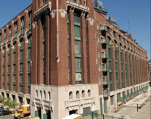 A large,historical brick building featuring architectural details,multiple windows,and decorative elements.