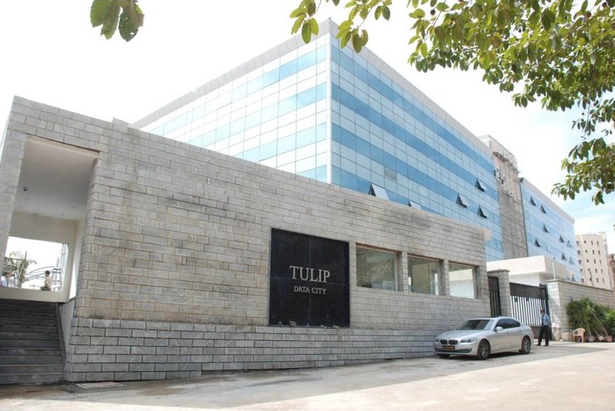 Exterior view of Tulip Data City,featuring a modern building with a stone façade and glass windows.