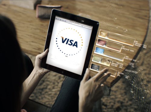 A person using a tablet displaying the Visa logo with a digital interface showing card options.