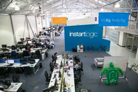 Wide view of the open office space at instartlogic with workstations and decor.