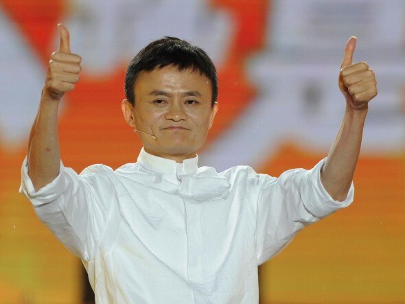 A person in a white outfit giving a thumbs-up gesture with both hands,smiling.