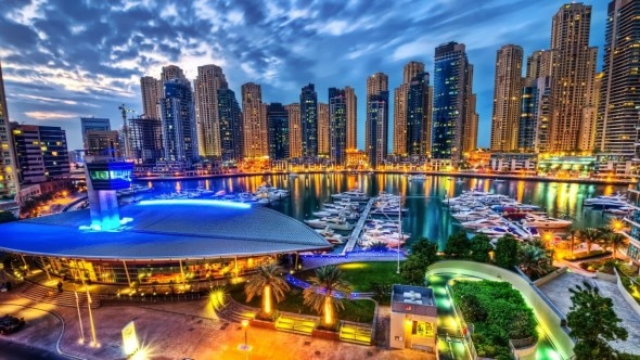 Stunning view of Dubai Marina at night with illuminated buildings and yachts.