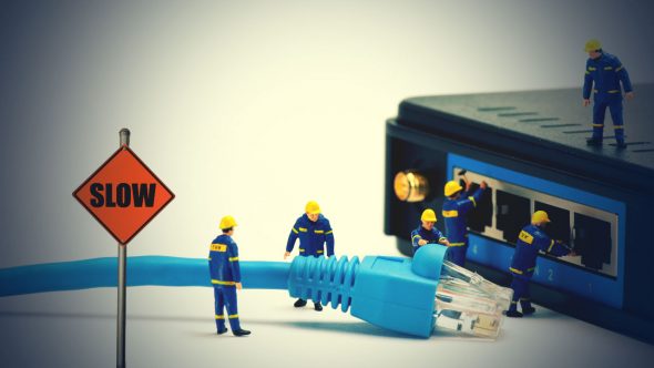 Miniature figures of workers fixing a router with a sign indicating 'SLOW' next to a blue ethernet cable.