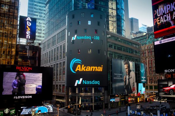 A view of Times Square featuring large digital billboards,including advertisements for Akamai and Nasdaq.