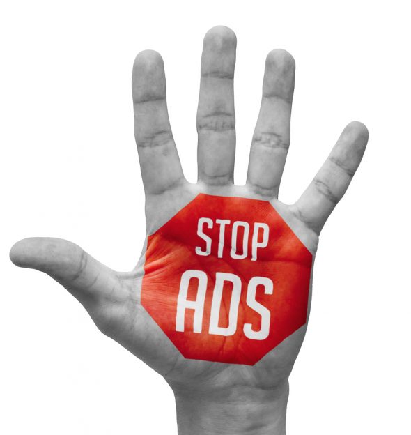 A black and white image of an open hand featuring a red octagonal sign with the text 'STOP ADS' in white.