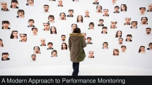 A person observing a wall of diverse faces in a modern art setting.