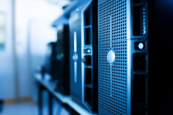 A close-up view of several desktop computers lined up on a table,featuring a modern design and a blue hue.