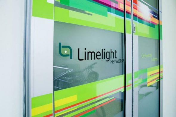 Signage of Limelight Networks displayed on a glass door,featuring colorful geometric patterns.