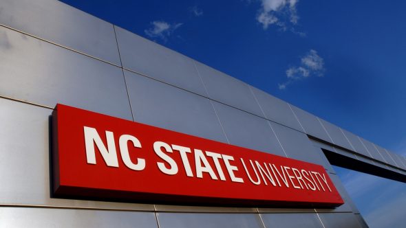 Sign of NC State University against a blue sky.