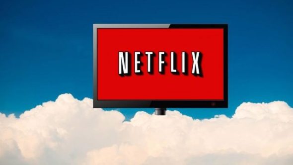 A large Netflix logo displayed on a digital screen against a blue sky with fluffy white clouds.