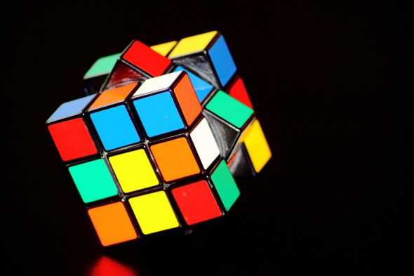 A colorful Rubik's Cube with various colored squares on each face,partially rotated to show multiple angles.