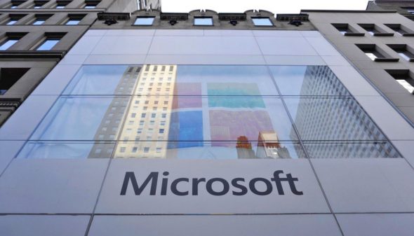 Facade of a Microsoft store with a large window displaying colorful panels and the Microsoft logo.