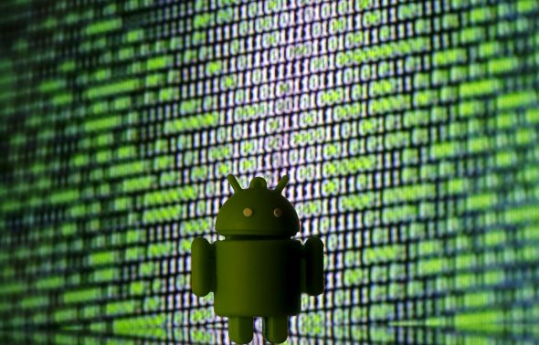 A green Android figurine in front of a digital display featuring binary code.