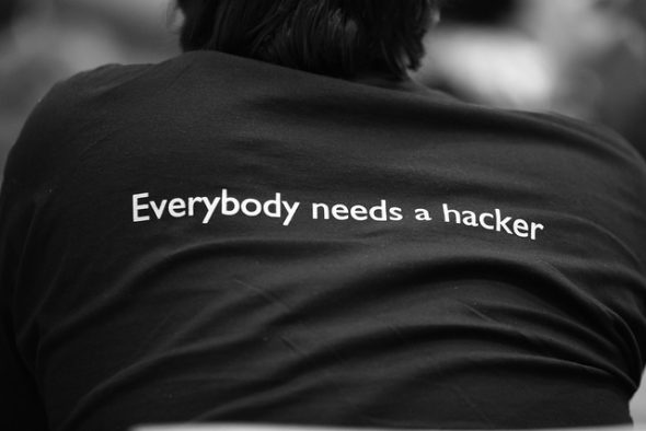 A black t-shirt with the text 'Everybody needs a hacker' printed on the back.