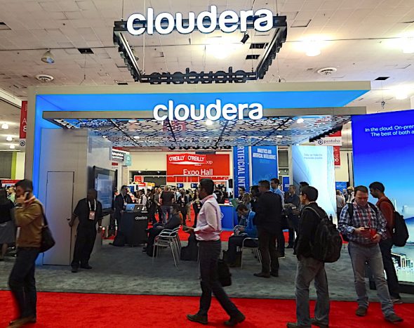 Cloudera booth at an event with attendees and vibrant setup.