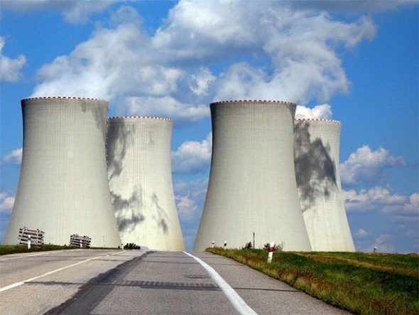 Cooling towers of a nuclear power plant under a blue sky with clouds.