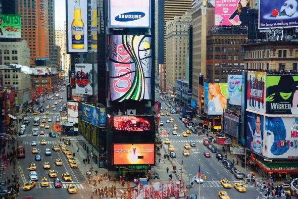 Aerial view of Times Square with bright billboards and busy streets filled with yellow taxis.