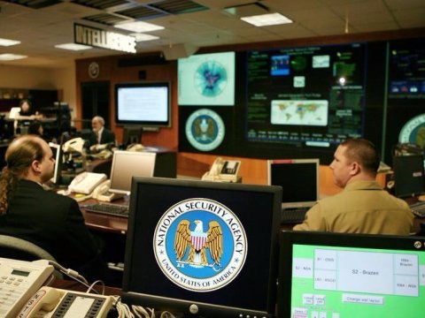 NSA command center with personnel monitoring data on multiple screens.