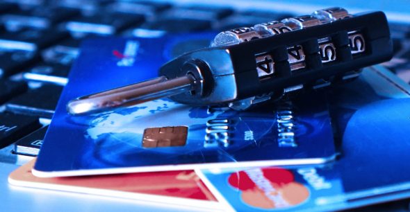 Close-up of credit cards and a security lock on a keyboard.