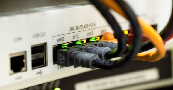 Close-up view of a network switch with connected Ethernet cables and indicator lights.