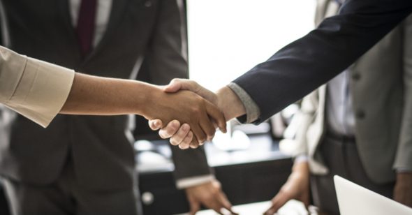 A close-up of two people shaking hands in a business setting