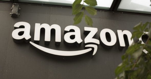 The Amazon logo displayed on a storefront,featuring the company's name in white letters with a curved arrow underneath.