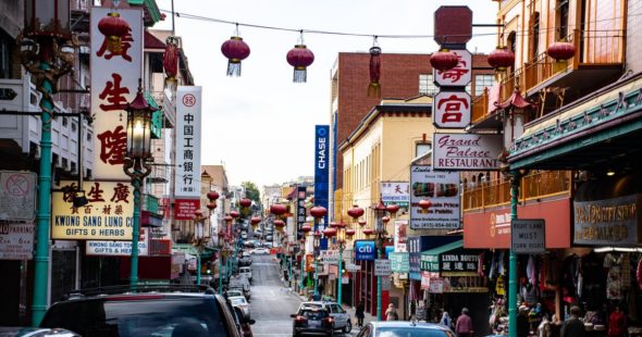 A busy street in Chinatown adorned with lanterns and colorful shop signs.