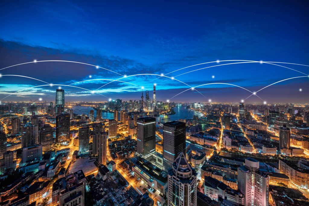 Aerial view of a city at night with glowing network connections.