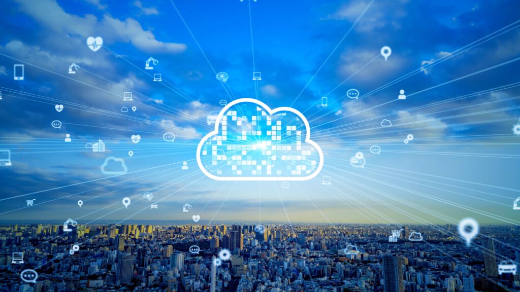 A digital cloud icon surrounded by various technology and communication symbols against a skyline and blue sky.