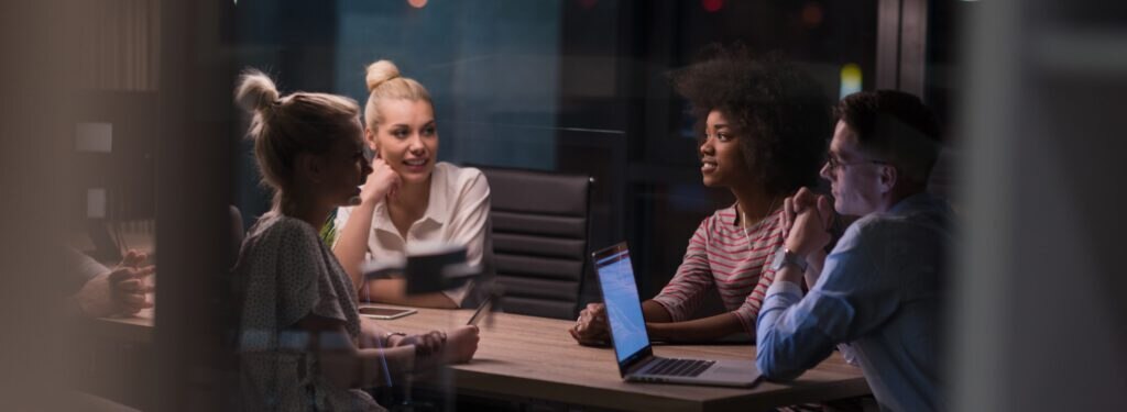 A group of four people engaged in a business discussion around a table