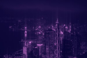 A vibrant night view of a city skyline illuminated in shades of purple.