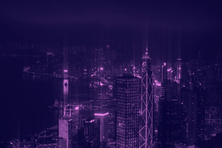 A vibrant night view of a city skyline illuminated in shades of purple.