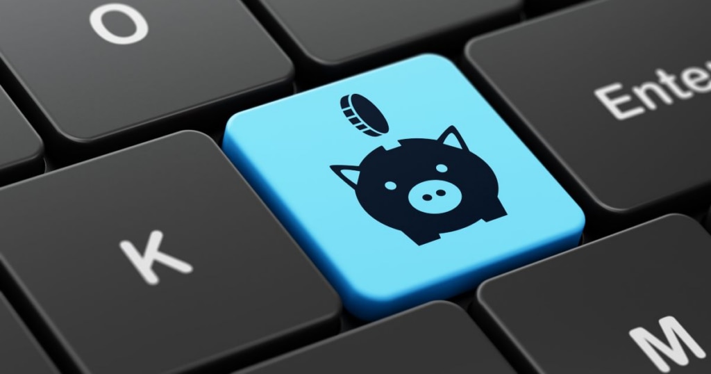 A close-up of a keyboard with a blue key featuring a piggy bank icon and a coin above it.