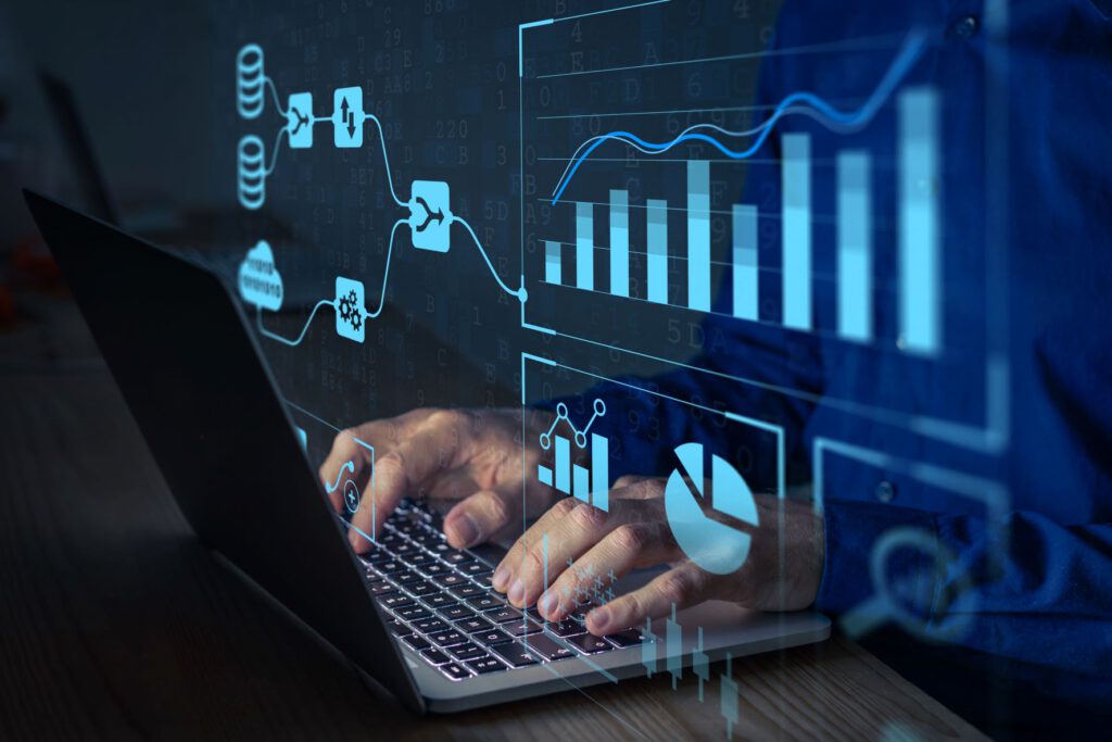 A close-up of hands typing on a laptop with digital graphs and data visualizations overlaying the image.