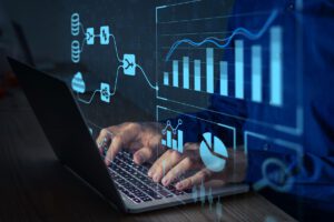 A close-up of hands typing on a laptop with digital graphs and data visualizations overlaying the image.