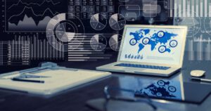 Laptop displaying data analytics on a desk with graphs and charts.