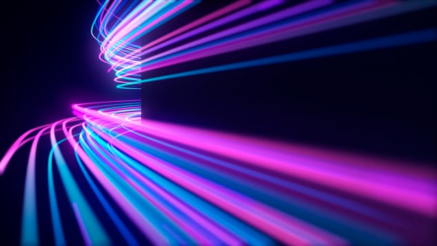 Abstract image of vibrant light trails in purple and blue colors against a dark background.