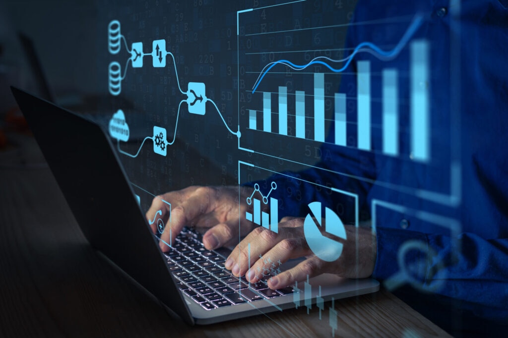 A person typing on a laptop with digital graphs and data visualization overlay.