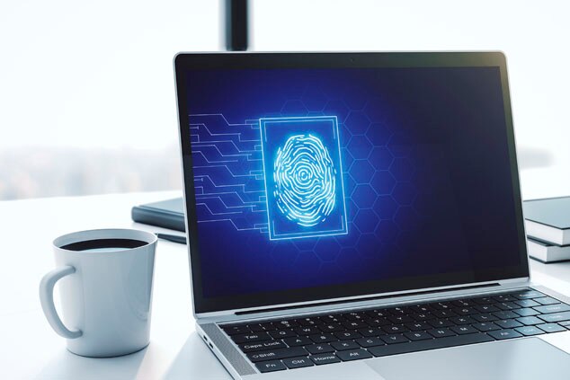 A laptop displaying a digital fingerprint authentication interface,accompanied by a coffee cup on a desk.