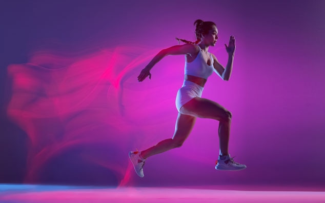 A dynamic image of a female athlete in motion,running against a vibrant,colorful background.