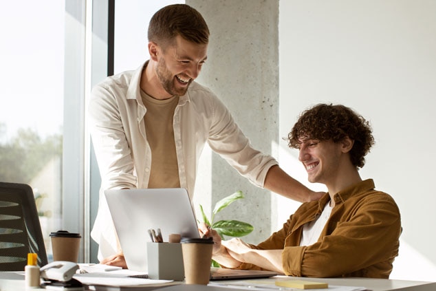 Two men laughing and engaging positively in a work environment