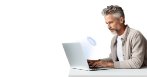 A man with gray hair working on a laptop,focused on the screen.