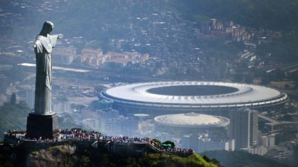 Aerial view of the Christ the Redeemer statue overlooking a stadium in a city.