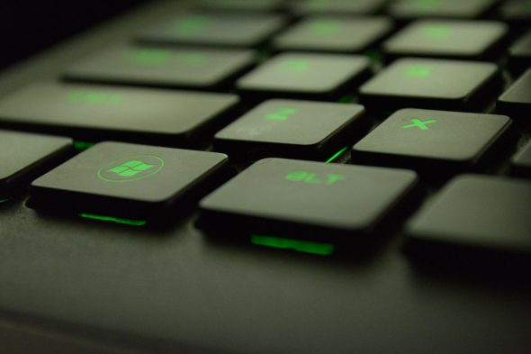 Close-up view of a computer keyboard with green backlit keys.